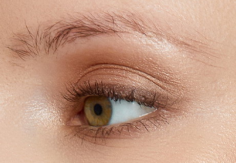 Close-up on an eye with sparse eyebrows looking away from the camera